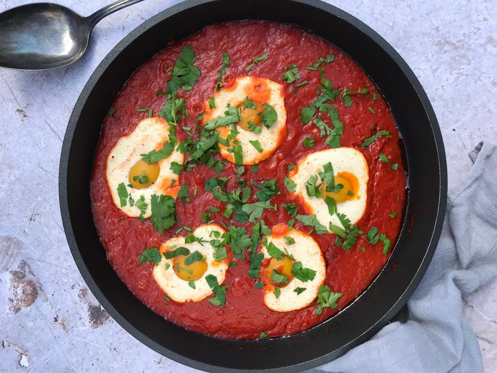 Shakshuka vegana con huevos veganos caseros sobre una salsa de tomate