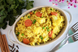 Bandeja ovalada con arroz biryani, se distinguen el arroz y las verduras.